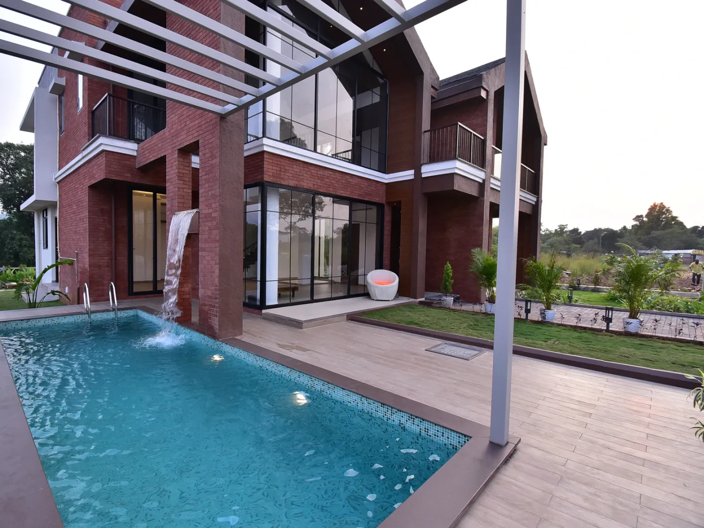 Poolside villa with a deep roof and pergola shading glazed living spaces.