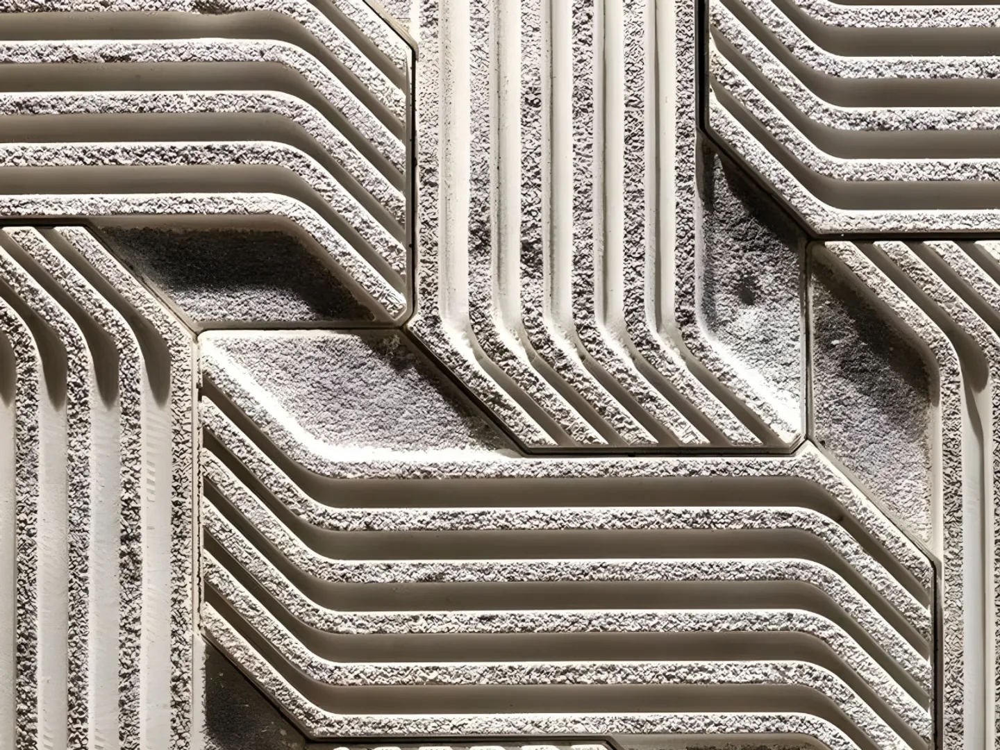 Close-up of deeply grooved modular wall panels with a granular texture.