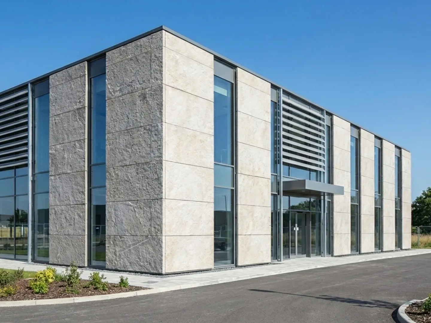 Daylit contemporary facade combining stone panels, glass and metal louvers.