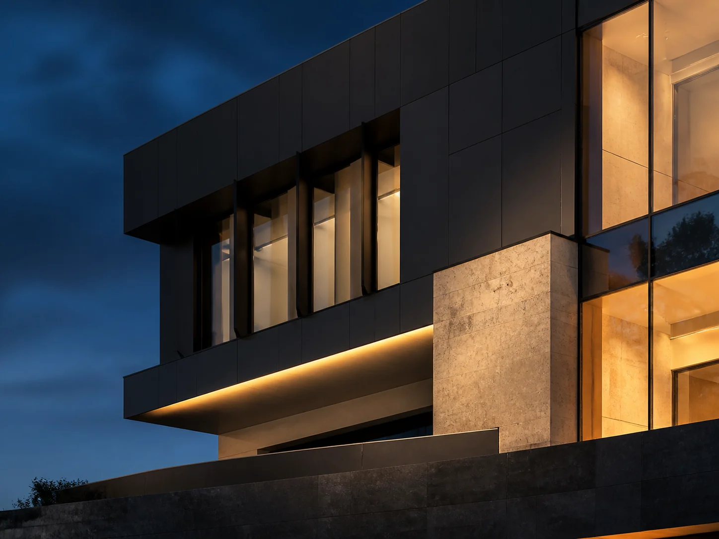Contemporary facade of dark panels, stone and glass at dusk.