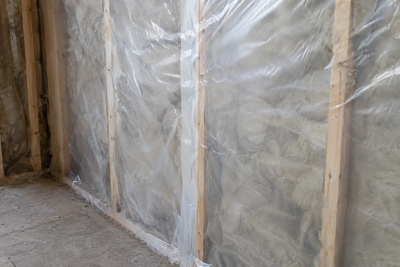 A translucent sheet spans timber framing with a vertical taped overlap and visible wrinkles.